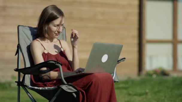 Chica utilizando la tecnología en un prado con portátil — Vídeos de Stock