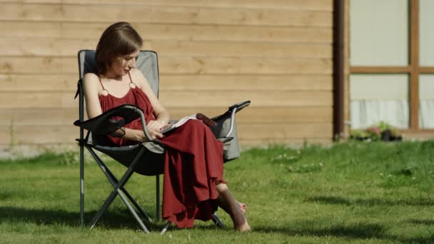 Enfants regardant une tablette photo avec leur mère dans un parc — Video