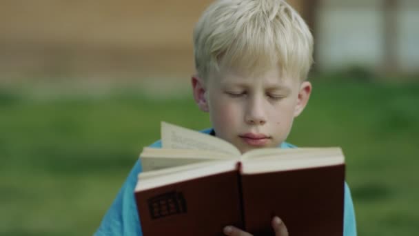 Junge liest ein Buch — Stockvideo