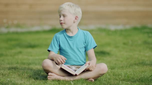 Jongen die een boek leest — Stockvideo