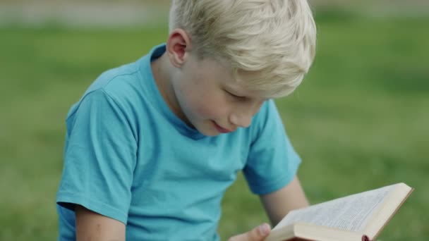 Хлопчик читає книгу — стокове відео