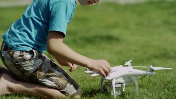 Anak merakit modern dengung di rumput hijau halaman. Memakai baling-baling — Stok Video