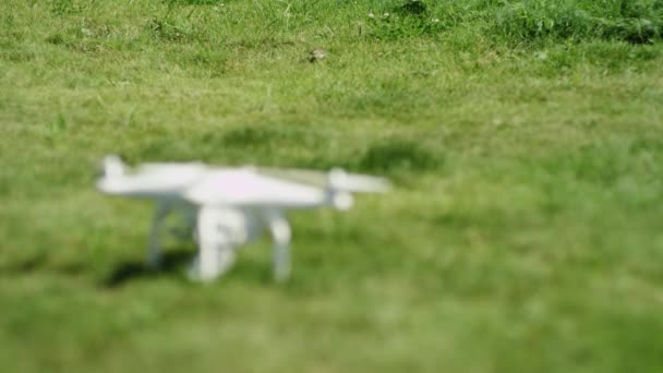 Quadrocopter steht auf dem Gras. Grüner Hintergrund. Sommer — Stockvideo