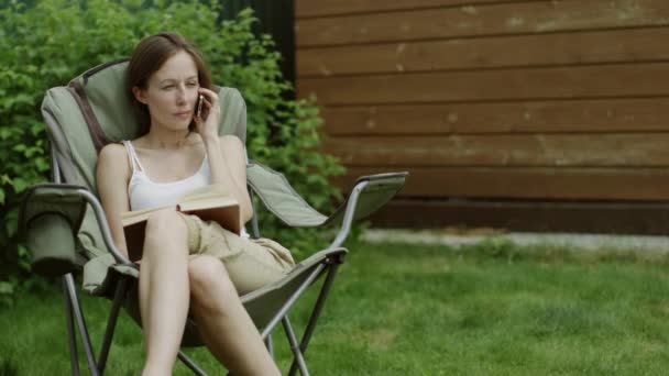 Mujer con un teléfono al aire libre — Vídeo de stock