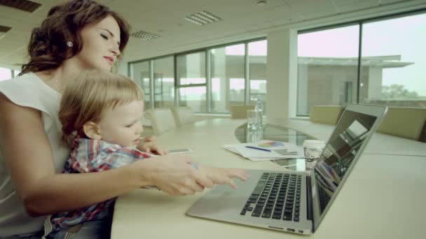 Business woman and her child typing on laptop — стоковое видео