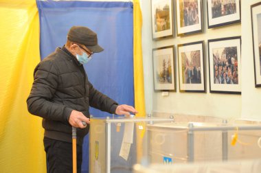 Lviv, Ukrayna, 25 Ekim 2020. 2020 Ukrayna yerel seçimleri. Yerel seçimler sırasında sandık merkezinde insanlar oy kullanıyor. Ekim 2020 'de devam eden Coronavirus COVID-19 salgınının ortasında. Ülkenin dört bir yanındaki Ukraynalılar seçim için sandık başına gitti. 