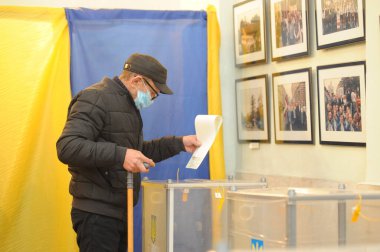 Lviv, Ukrayna, 25 Ekim 2020. 2020 Ukrayna yerel seçimleri. Yerel seçimler sırasında sandık merkezinde insanlar oy kullanıyor. Ekim 2020 'de devam eden Coronavirus COVID-19 salgınının ortasında. Ülkenin dört bir yanındaki Ukraynalılar seçim için sandık başına gitti. 