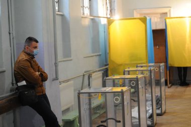 Lviv, Ukrayna, 25 Ekim 2020. 2020 Ukrayna yerel seçimleri. Yerel seçimler sırasında sandık merkezinde insanlar oy kullanıyor. Ekim 2020 'de devam eden Coronavirus COVID-19 salgınının ortasında. Ülkenin dört bir yanındaki Ukraynalılar seçim için sandık başına gitti. 