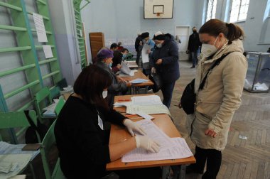 Lviv, Ukrayna, 25 Ekim 2020. 2020 Ukrayna yerel seçimleri. Yerel seçimler sırasında sandık merkezinde insanlar oy kullanıyor. Ekim 2020 'de devam eden Coronavirus COVID-19 salgınının ortasında. Ülkenin dört bir yanındaki Ukraynalılar seçim için sandık başına gitti. 