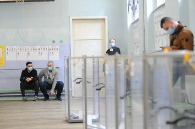Lviv, Ukrayna, 25 Ekim 2020. 2020 Ukrayna yerel seçimleri. Yerel seçimler sırasında sandık merkezinde insanlar oy kullanıyor. Ekim 2020 'de devam eden Coronavirus COVID-19 salgınının ortasında. Ülkenin dört bir yanındaki Ukraynalılar seçim için sandık başına gitti. 