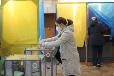 Lviv, Ukrayna, 25 Ekim 2020. 2020 Ukrayna yerel seçimleri. Yerel seçimler sırasında sandık merkezinde insanlar oy kullanıyor. Ekim 2020 'de devam eden Coronavirus COVID-19 salgınının ortasında. Ülkenin dört bir yanındaki Ukraynalılar seçim için sandık başına gitti. 