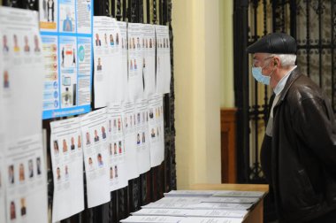 Lviv, Ukrayna, 25 Ekim 2020. 2020 Ukrayna yerel seçimleri. Yerel seçimler sırasında sandık merkezinde insanlar oy kullanıyor. Ekim 2020 'de devam eden Coronavirus COVID-19 salgınının ortasında. Ülkenin dört bir yanındaki Ukraynalılar seçim için sandık başına gitti. 