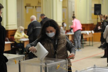 Lviv, Ukrayna, 25 Ekim 2020. 2020 Ukrayna yerel seçimleri. Yerel seçimler sırasında sandık merkezinde insanlar oy kullanıyor. Ekim 2020 'de devam eden Coronavirus COVID-19 salgınının ortasında. Ülkenin dört bir yanındaki Ukraynalılar seçim için sandık başına gitti. 