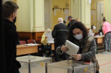 Lviv, Ukrayna, 25 Ekim 2020. 2020 Ukrayna yerel seçimleri. Yerel seçimler sırasında sandık merkezinde insanlar oy kullanıyor. Ekim 2020 'de devam eden Coronavirus COVID-19 salgınının ortasında. Ülkenin dört bir yanındaki Ukraynalılar seçim için sandık başına gitti. 