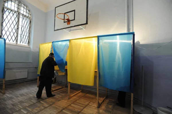 Lviv, Ukrayna, 25 Ekim 2020. 2020 Ukrayna yerel seçimleri. Yerel seçimler sırasında sandık merkezinde insanlar oy kullanıyor. Ekim 2020 'de devam eden Coronavirus COVID-19 salgınının ortasında. Ülkenin dört bir yanındaki Ukraynalılar seçim için sandık başına gitti. 