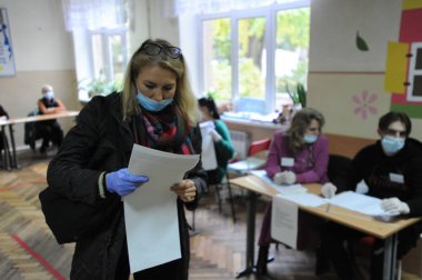 Lviv, Ukrayna, 25 Ekim 2020. 2020 Ukrayna yerel seçimleri. Yerel seçimler sırasında sandık merkezinde insanlar oy kullanıyor. Ekim 2020 'de devam eden Coronavirus COVID-19 salgınının ortasında. Ülkenin dört bir yanındaki Ukraynalılar seçim için sandık başına gitti. 
