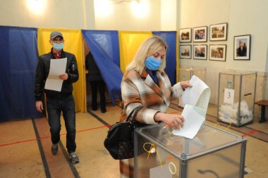 Lviv, Ukrayna, 25 Ekim 2020. 2020 Ukrayna yerel seçimleri. Yerel seçimler sırasında sandıkta oy kullanılıyor. Ekim 2020 'de devam eden Coronavirus COVID-19 pandemiği üzerine. Ukraynalılar yerel seçimler için sandık başına gittiler.. 