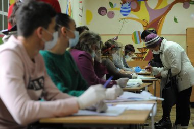 Lviv, Ukrayna, 25 Ekim 2020. 2020 Ukrayna yerel seçimleri. Yerel seçimler sırasında sandıkta oy kullanılıyor. Ekim 2020 'de devam eden Coronavirus COVID-19 pandemiği üzerine. Ukraynalılar yerel seçimler için sandık başına gittiler.. 