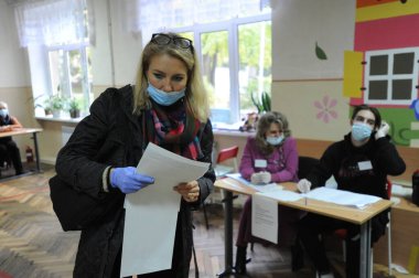 Lviv, Ukrayna, 25 Ekim 2020. 2020 Ukrayna yerel seçimleri. Yerel seçimler sırasında sandıkta oy kullanılıyor. Ekim 2020 'de devam eden Coronavirus COVID-19 pandemiği üzerine. Ukraynalılar yerel seçimler için sandık başına gittiler.. 