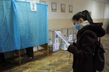 Lviv, Ukrayna, 25 Ekim 2020. 2020 Ukrayna yerel seçimleri. Yerel seçimler sırasında sandık merkezinde insanlar oy kullanıyor. Ekim 2020 'de devam eden koronavirüs COVID-19 salgınının ortasında.