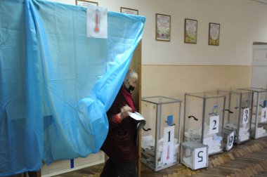 Lviv, Ukrayna, 25 Ekim 2020. 2020 Ukrayna yerel seçimleri. Yerel seçimler sırasında sandık merkezinde insanlar oy kullanıyor. Ekim 2020 'de devam eden koronavirüs COVID-19 salgınının ortasında.