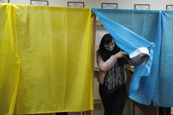 Lviv, Ukrayna, 25 Ekim 2020. 2020 Ukrayna yerel seçimleri. Yerel seçimler sırasında sandık merkezinde insanlar oy kullanıyor. Ekim 2020 'de devam eden Coronavirus COVID-19 salgınının ortasında. Ülkenin dört bir yanındaki Ukraynalılar seçim için sandık başına gitti. 