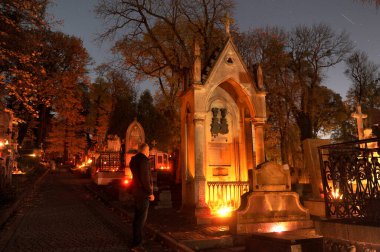 Lviv, Ukrayna, 1 Kasım 2020. Ukraynalılar, Ukrayna 'nın Lviv kentindeki Lychakiv Mezarlığında Azizler Günü' nü kutlamak için 'Lychakiv Mezarlığı için Hafıza Mumları' etkinliği sırasında mum yaktılar. Lychakiv Mezarlığı Avrupa 'daki en eski mezarlıklardan biridir..