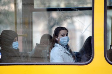 Lviv, Ukrayna, 4 Kasım 2020. Koronavirüsün önleyici önlemi olarak yüz maskesi takan insanlar toplu taşıma tramvayında otururlar.. 
