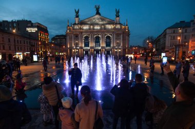 Lviv, Ukrayna, 4 Kasım 2020. İnsanlar Lviv Opera Binası yakınlarında Socar şirketi tarafından yapılmış yeni fıskiyelerle fotoğraf çekiyor.. 