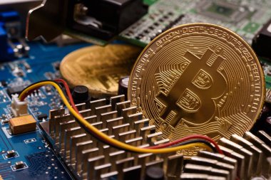 Bu fotoğraf illüstrasyonunda, devre kartındaki Bitcoin şifreleme hatıra paraları.