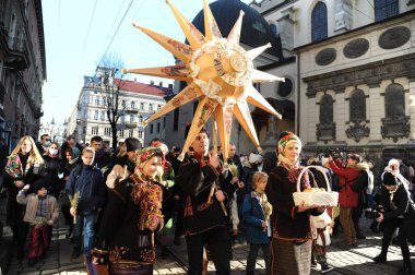 Lviv, Ukrayna 6 Ocak 2021. Ukraynalılar Beytüllahim 'in süslü yıldızlarını ve buğday demetlerini taşırken Noel şarkıları söylüyorlar. Eski Julian takvimine göre Ukraynalı inananlar Ortodoks Noel Gününü 07 Ocak 'ta kutladılar.