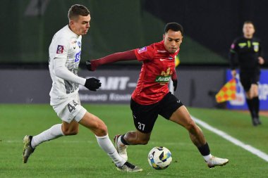 Zhytomyr, Ukrayna 13 Aralık 2025. Karpaty 'den Bruninho, Polissya' dan Sergiy Chobotenko 'ya karşı Ukrayna Premier Ligi karşılaşmasında FC Polissya Zhytomyr' e karşı FC Karpaty Lviv