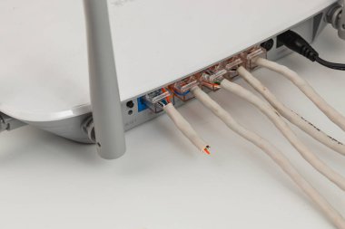 Bir ağ aygıtı sırtına birden fazla kablo bağlanmış bir masanın üzerine yerleştirilir. Ayarlar düzenli bir çalışma alanı için düzenlenmiş kabloları gösteriyor.