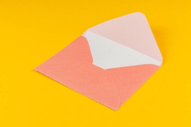 Pembe ve beyaz bir zarf parlak sarı bir arkaplanda duruyor, mektuplar ya da davetiyeler için hazır. Neşeli bir dokunuş ekliyor, özel durumlar veya notlar için mükemmel..
