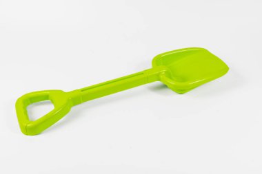 Lviv Ukrayna 12.08.2025 parlak yeşil oyuncak kürek beyaz bir yüzeyde duruyor. Çocukların dışarıda ya da arka bahçede kum ve kir içinde kullanabilmesi için tasarlanmıştır..