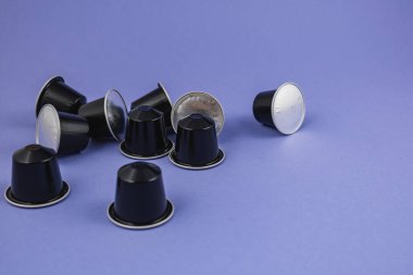 Lviv Ukrayna 12.08.2025 çeşitli kahve kapsülleri mavi bir yüzeye saçılmıştır. Kapsüllerin koyu ve gümüş renkli tasarımları var, demlenmek için çeşitli kahve seçeneklerini gösteriyor.