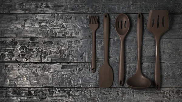 Un conjunto de accesorios de cocina cuidadosamente apilados en una mesa de madera. — Foto de Stock