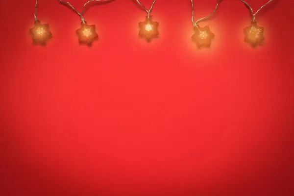 Žhnoucí věnec pěti žárovek na červeném pozadí. — Stock fotografie