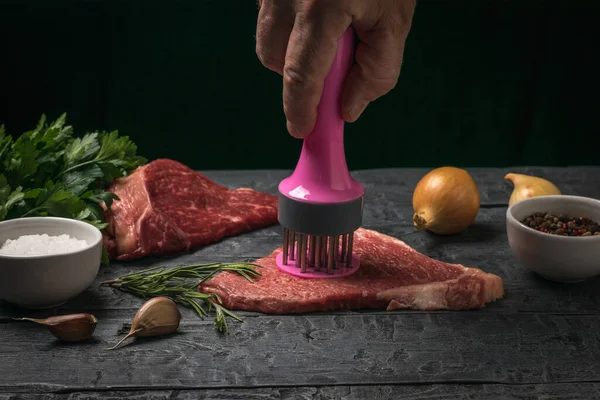 특별 한 기구를 사용하여 쇠고기 스테이크를 준비하는 사람. — 스톡 사진