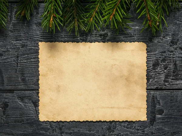 Arkusz starego zużytego papieru na drewnianym tle z gałązkami jodły. Formularz życzeń i pozdrowień. — Zdjęcie stockowe