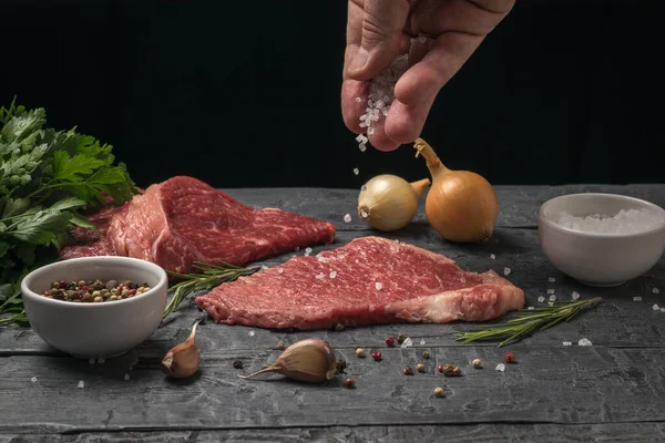 Um homem prepara costeletas de bifes de vaca. — Fotografia de Stock