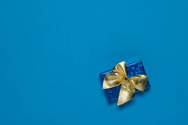 Mavi arka planda altın kurdeleli mavi bir kulübe..