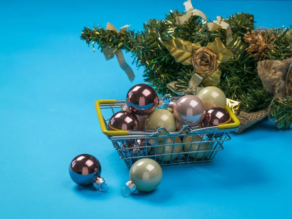 Kovový koš se skleněnými kuličkami na pozadí vánočního stromku. — Stock fotografie