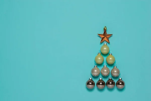 Vánoční stromek ze skleněných kuliček s hvězdou na modrém pozadí. — Stock fotografie