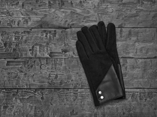 Czarno-biały wizerunek rękawiczek damskich na drewnianym stole. — Zdjęcie stockowe