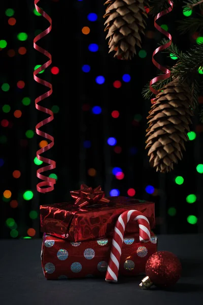 Ajándékok és édességek egy karácsonyfa alatt bokeh háttérrel. — Stock Fotó