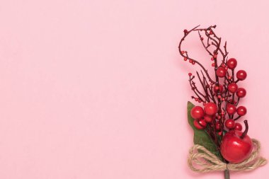 Açık kırmızı arkaplanda noel süslemesi.