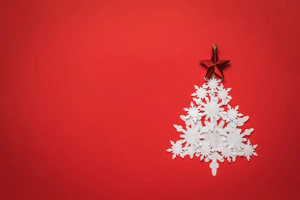 크리스마스 트리는 백지 눈송이로 만든 붉은 별이 배경에 있다. 원문을 위한 위치. — 스톡 사진