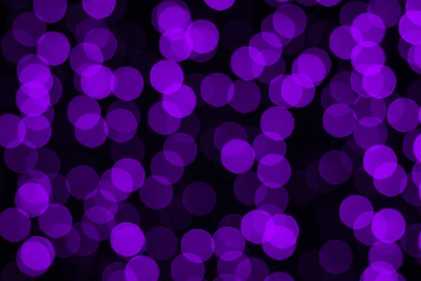 Blurry bokeh background in purple on black. — Stock Photo, Image