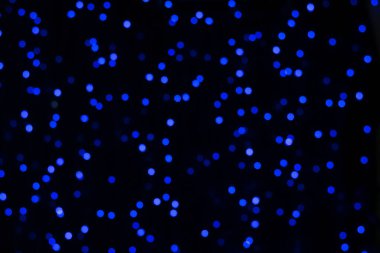 Küçük mavi bokeh ışıklarının bulanık arkaplanı.